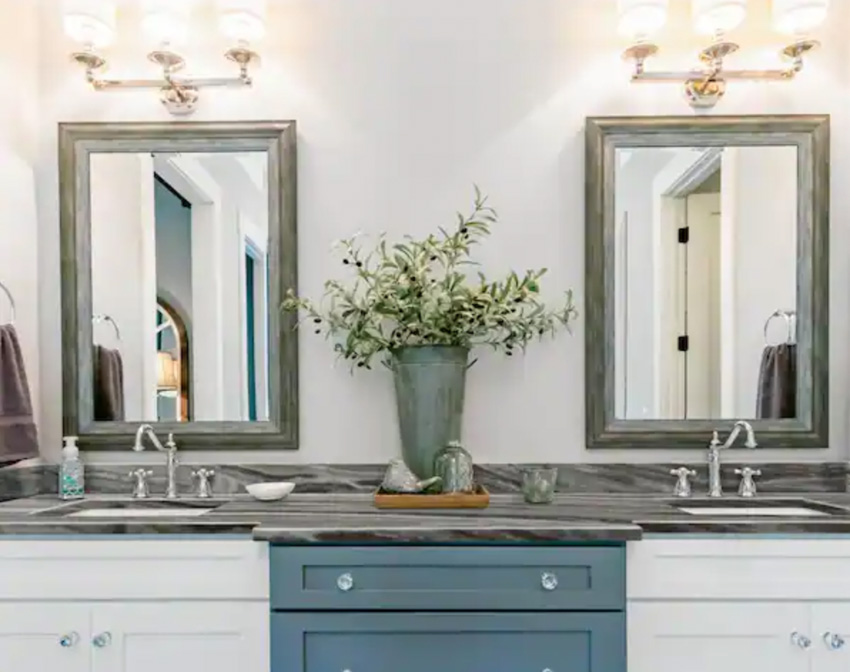 Vanity area with two mirrors, gray countertop, sink, and blue gray cabinets