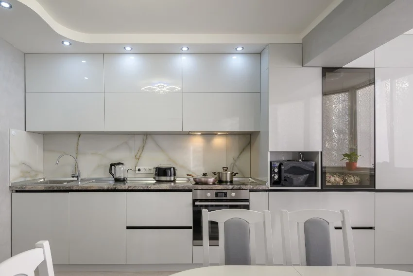 Kitchen with handleless cabinets, marble cabinets and dining set