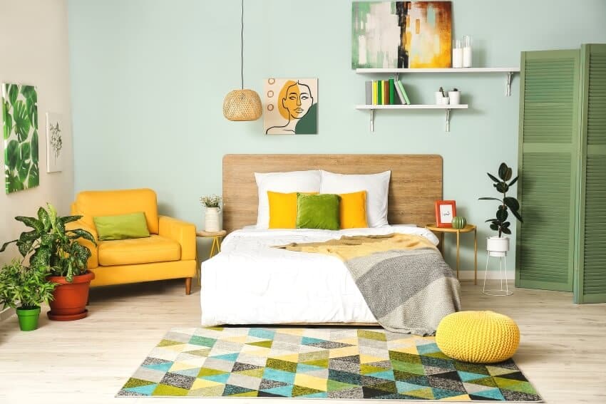 White and mint green walls of bedroom with yellow armchair 