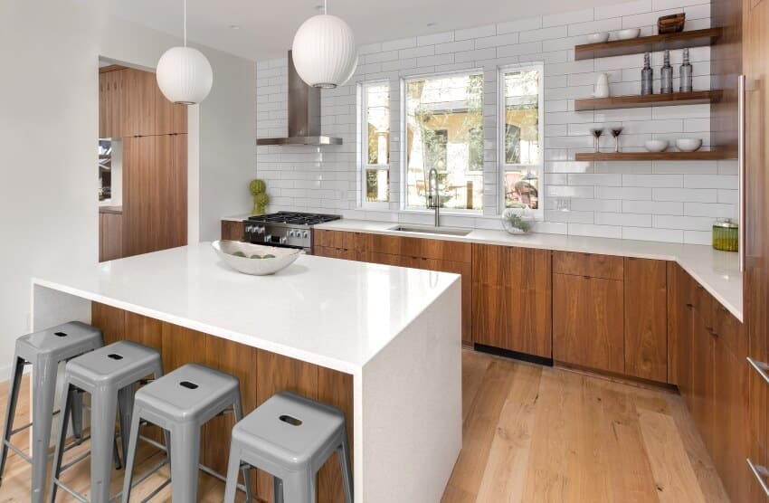 White kitchen with acacia wood cabinets, waterfall island, pendant lights, and hardwood floors