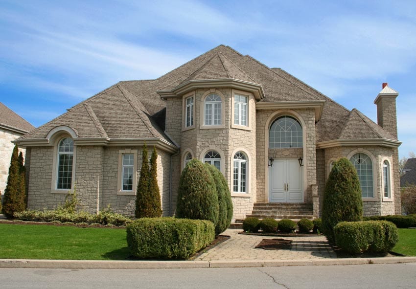 1990s house with stone wall cladding and arched windows