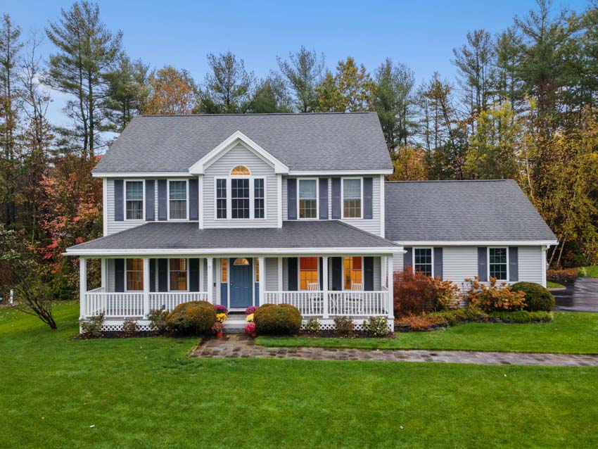 2000s house with large porch, and landscaped lawn