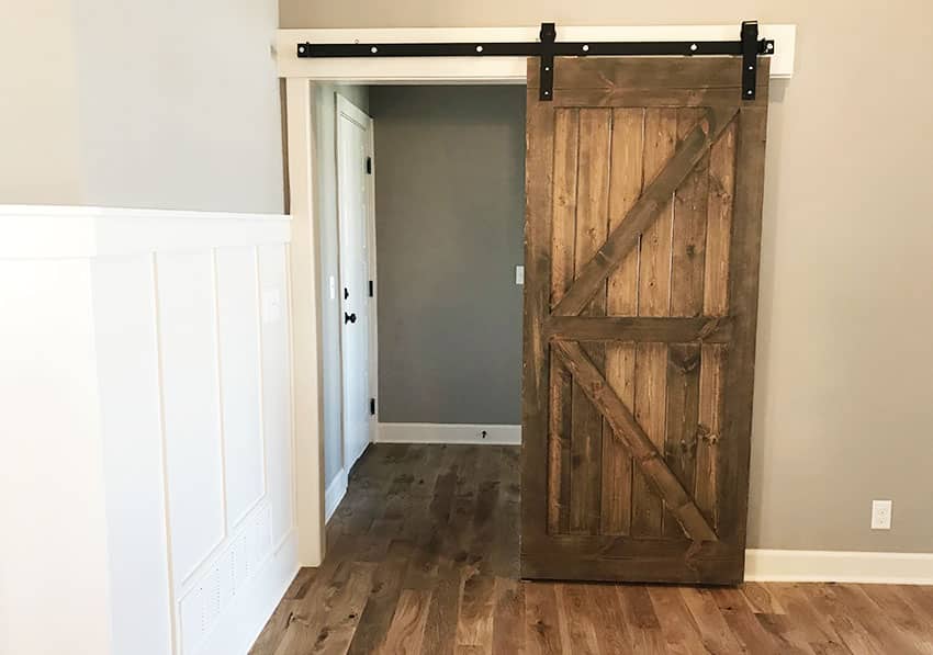 Bedroom with door, wooden floor board and batten wall