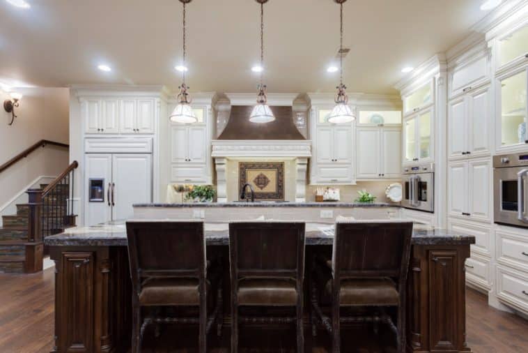 French Country Kitchen Backsplash   French Country Kitchen With Island Chairs Tile Backsplash White Cabinets Stove Wood Floors And Pendant Lights Is 758x506 