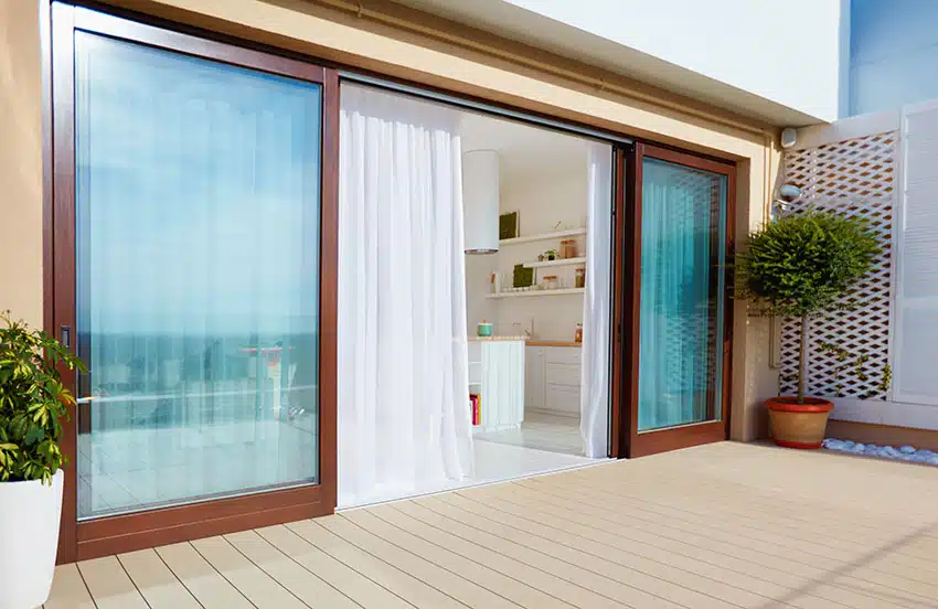 Large sliding glass door with white curtains
