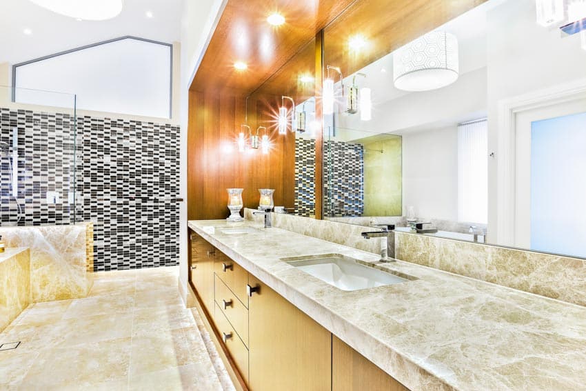 Bathroom with reglazed countertops, vanity mirror, cabinets, lighting fixtures, sink, faucet, and shower area