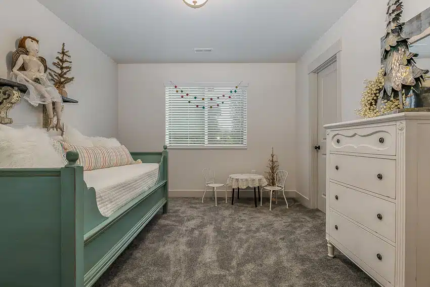 Bedroom with chalk paint bed frame, mattress, dresser, table, chairs, and window