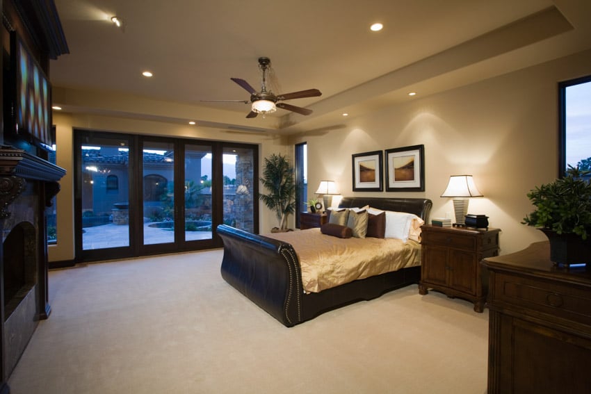 Bedroom with recessed light, dimmer control, ceiling fan, mattress, nightstand, and glass door