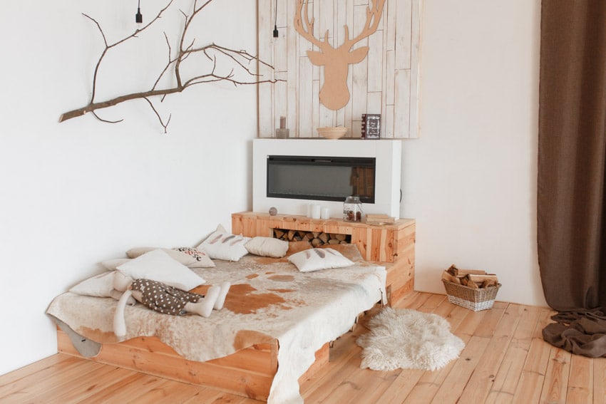 Bedroom with rustic pine wood headboard, wooden floors, mattress, pillows, and decor pieces
