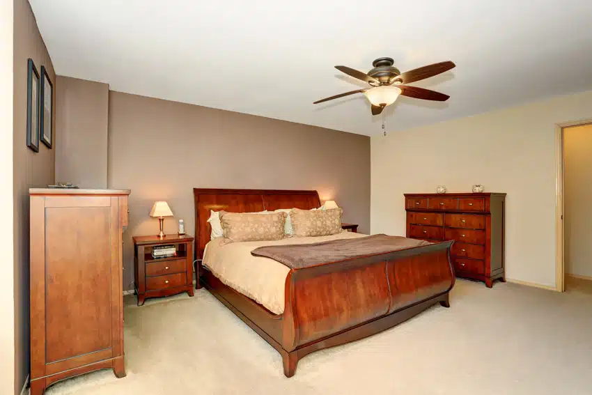 Bedroom with two dressers, ceiling fan, nightstand, lamps, and ceiling fans