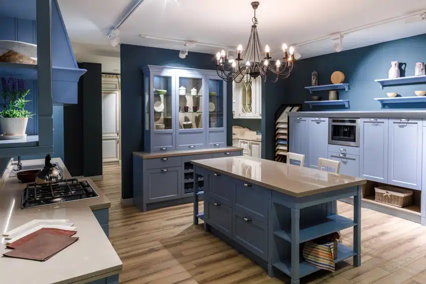 Kitchen with blue cabinets, solid surface counters and chandeliers