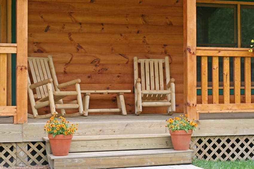 Cabin front porch with pine log wood chairs, log siding, and windows