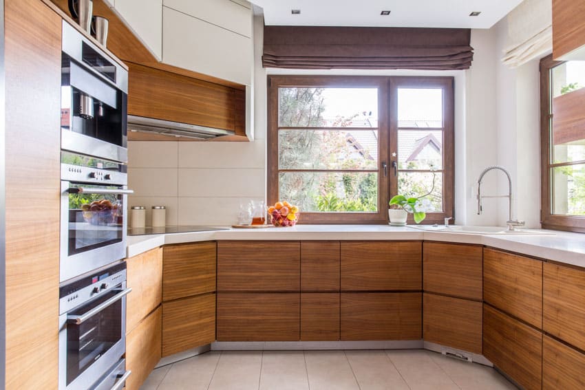 Classic kitchen with countertop, sink, faucet, oven, windows, and pressed wood cabinets