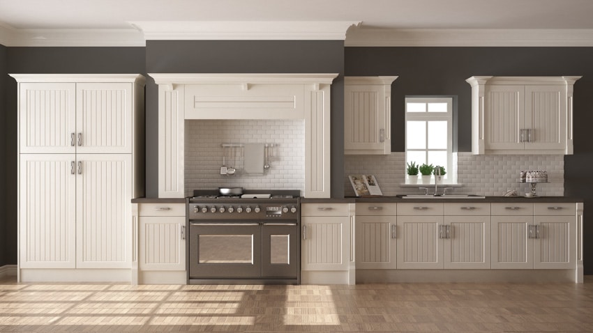 Contemporary kitchen with freestanding base cabinet, backsplash, oven, stove, countertop, and window
