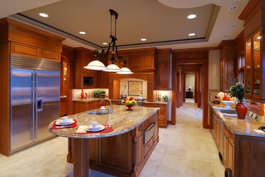 Contemporary kitchen with travertine tile floor, island, countertops, pendant lights, cabinets, refrigerator, and wood cabinets