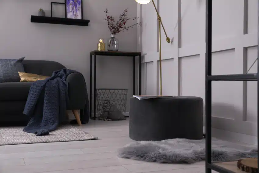 Contemporary living room with black modern pouf, couch, and side table