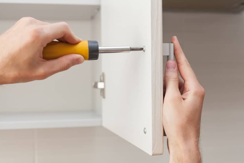 Contractor installing cabinet handle