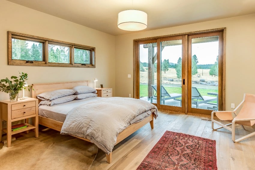 Cozy bedroom in beige tones with hardwood floors and simplistic shaker style furniture