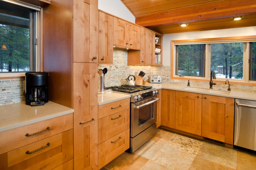 Craftsman kitchen with tile floor, countertop, cypress cabinets, and windows