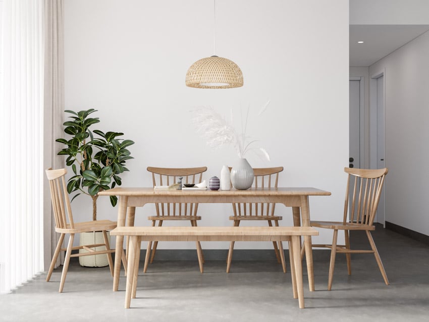 Dining room with pendant light, indoor plant, pine wood table, and chairs
