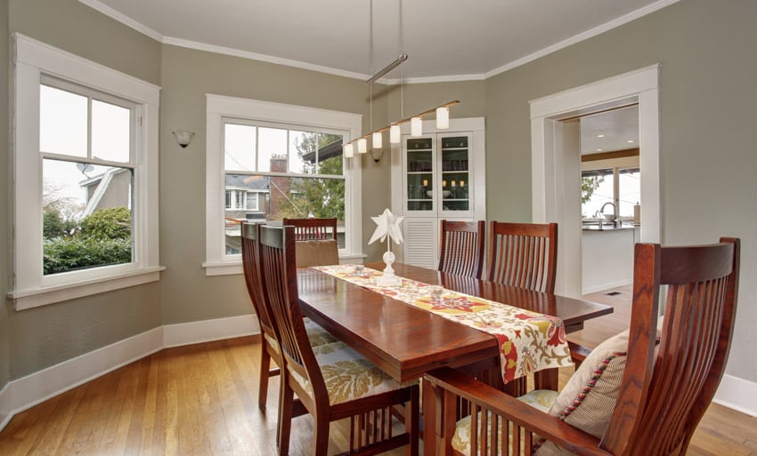 Dining set with floral table runner, wood flooring, pendant light and taupe walls