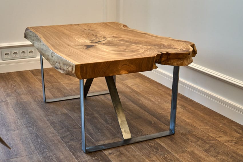 Table made of rough cut wood slab with metal base