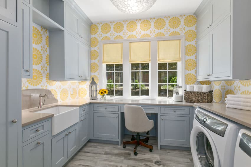 Farmhouse laundry room with curtains, wallpaper, sink, cabinets, washing machine, chair, and wood floor