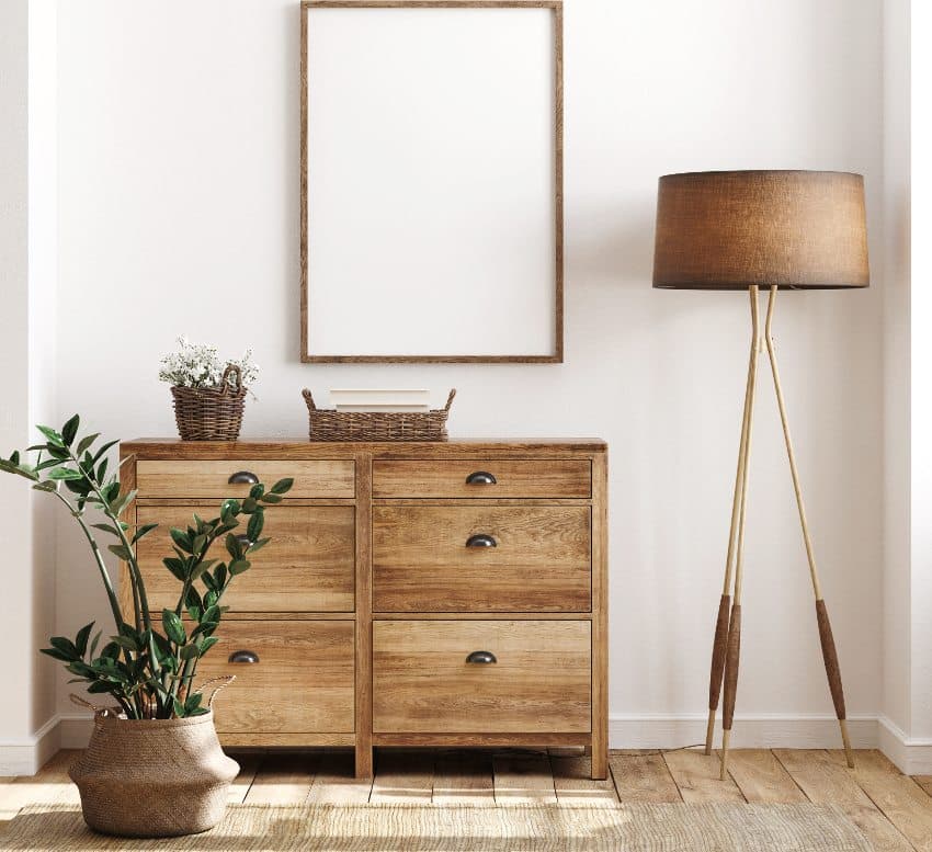 Side table with wicker baskets, wooden wall portrait and brown lamp