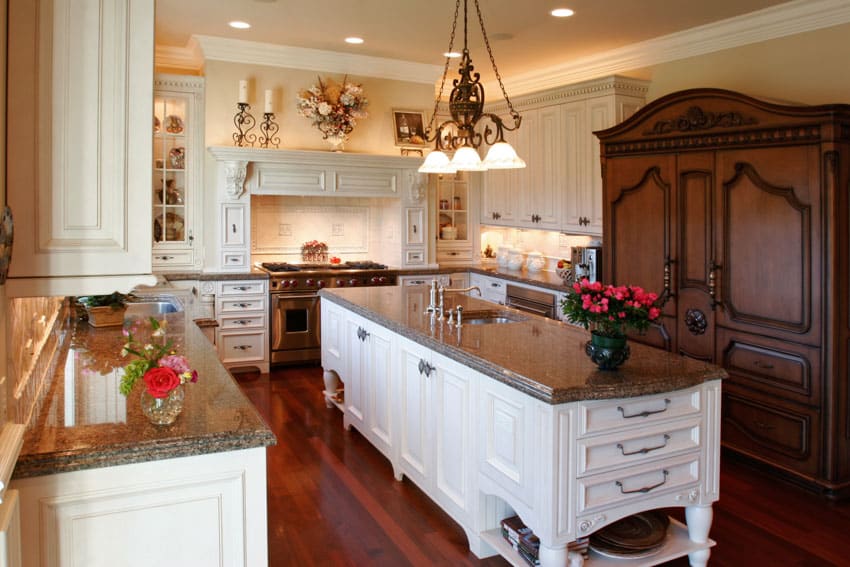 French country kitchen with freestanding cabinet made of wood, island, countertops, pendant lights, backsplash, and ceiling lights