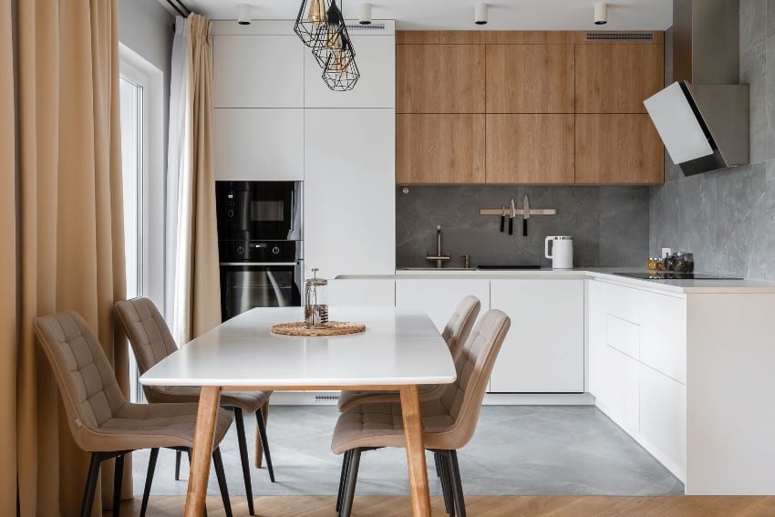 Minimalist kitchen with two tone cabinets, cage lighting, integrated appliances