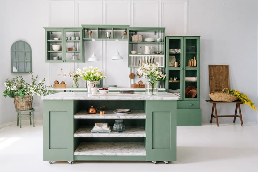 Green kitchen with freestanding cabinet with countertop, glass cabinets, chair, vases, and indoor plants