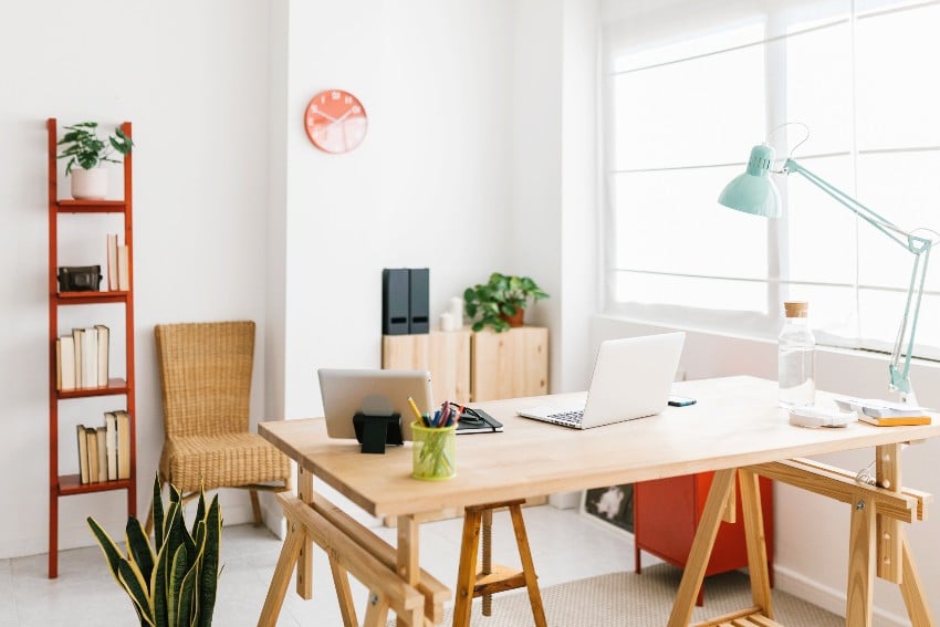 Home office workspace with wooden furniture, laptop computer and office supplies