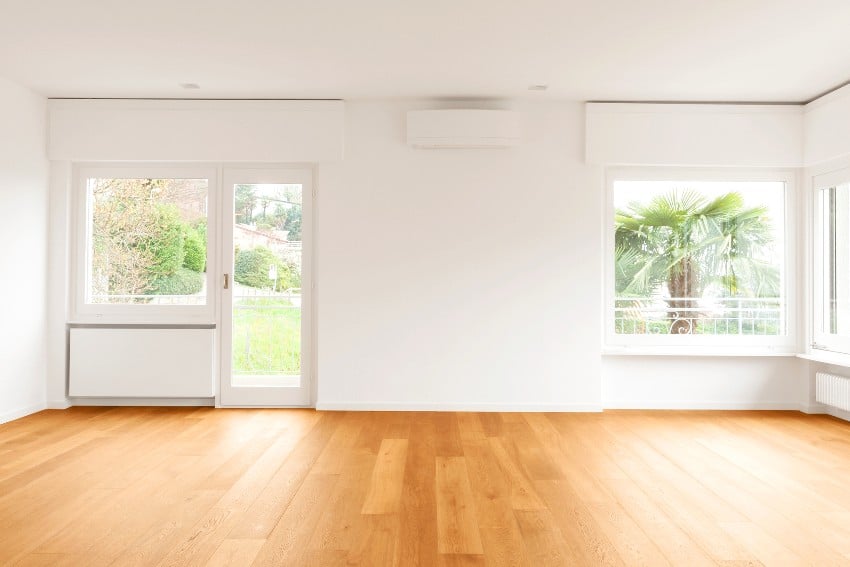 Empty room with picture window and light colored wood flooring
