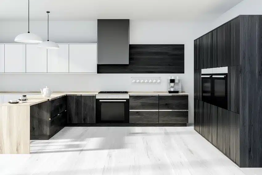 Interior of modern kitchen with white walls ,black ash wood cabinets and wooden countertops with two built in stoves