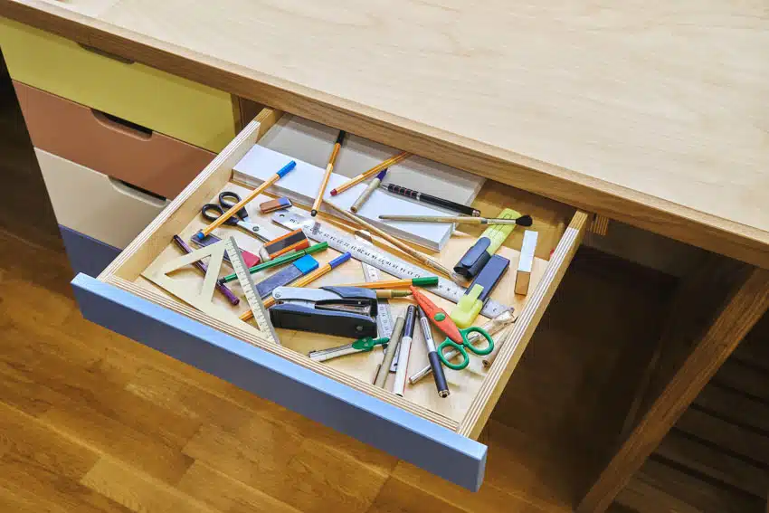 Pencils and pens inside a junk drawer
