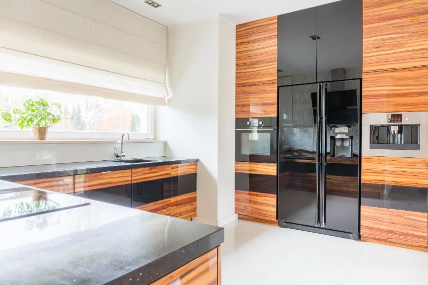 Kitchen features cabinets with glossy finish, black marble worktop