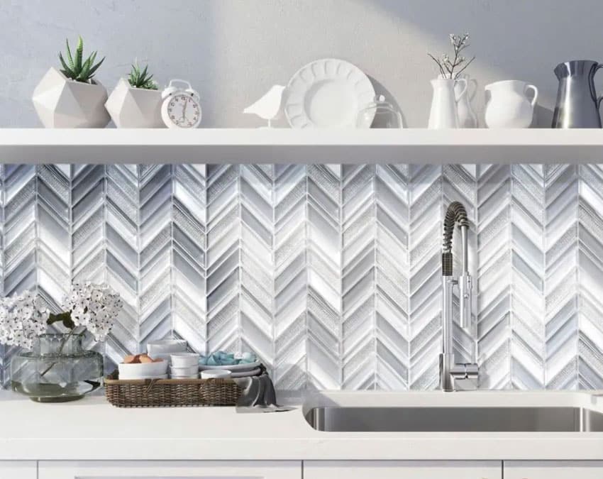 Kitchen with chevron mosaic tile, floating shelf, sink, faucet, and countertop