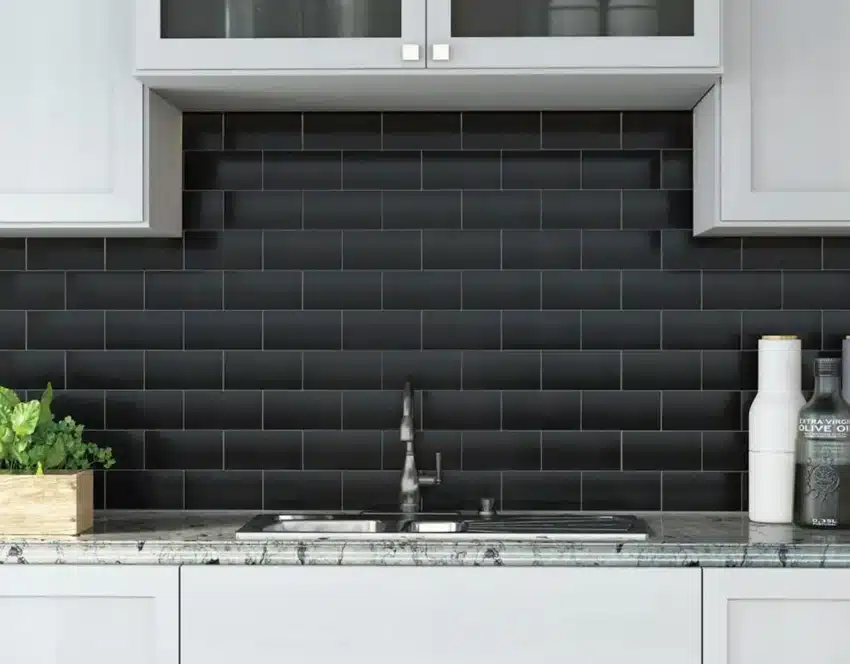 Kitchen with white cabinets, countertop, sink, faucet, and matte black subway tile backsplash