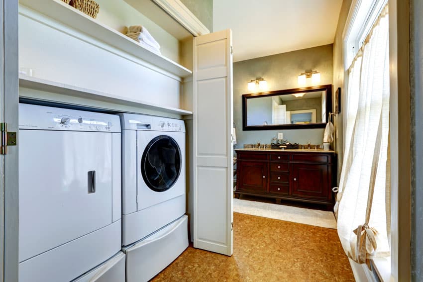 Laundry room with washing machine, dryer, shelves, and curtain