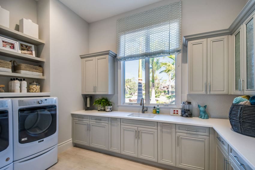 Laundry room with washing machine, dryer, white cabinets, window, curtain, and shelves