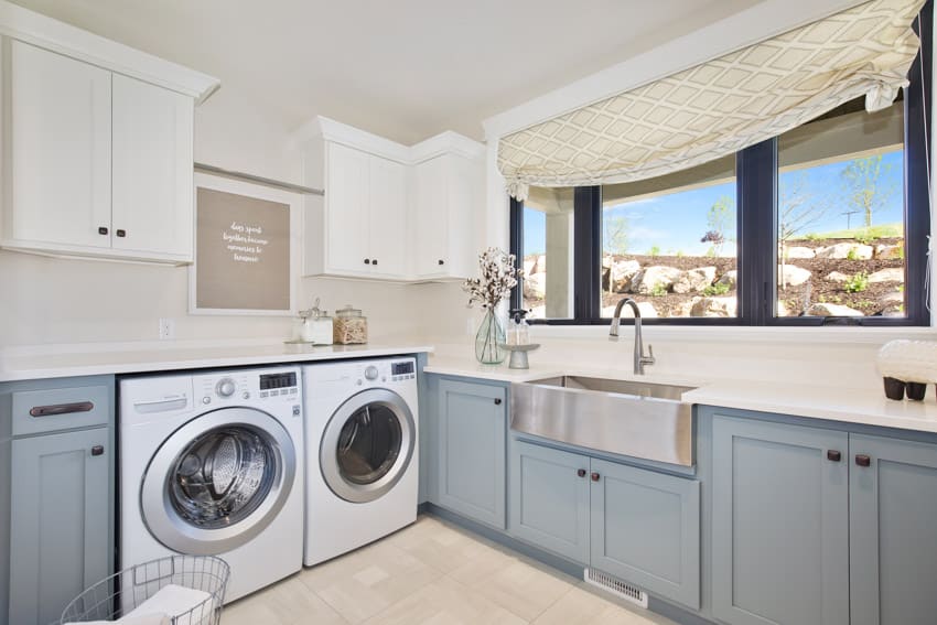 Laundry room with washing machine, dryer, window, curtain, cabinets, sink, countertop, and faucet