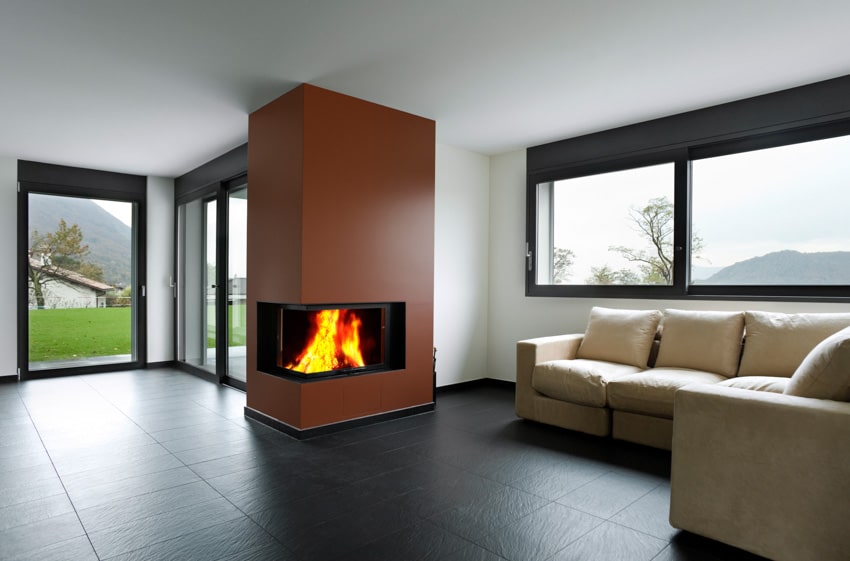 Living room with black matte porcelain tile floor, sofa, windows, and custom fireplace