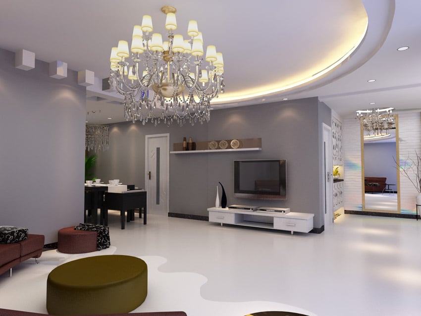 Room with curved ceiling lighting, ottoman, television and floating shelf