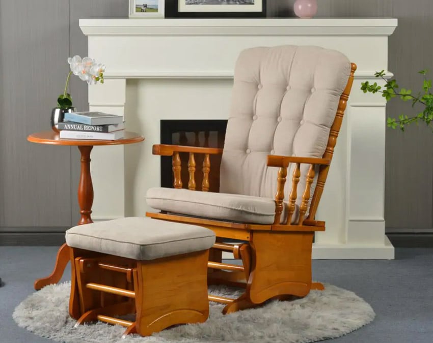 Living room with glider chair, ottoman, small table, rug, and fireplace