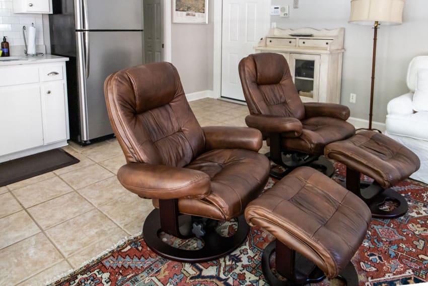 Living room with leather glider chairs, rug, and tile flooring