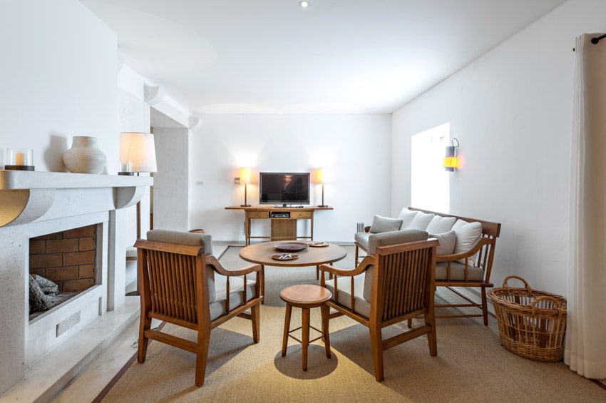 Room with slat back chairs, white walls and fireplace