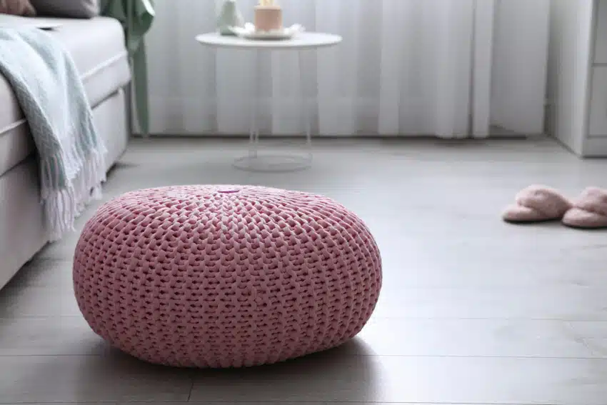 Living room with pink footstool pouf on wood floor