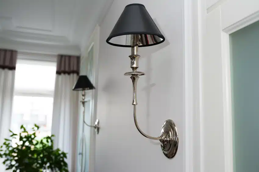 Black sconce with pewter body on white painted walls