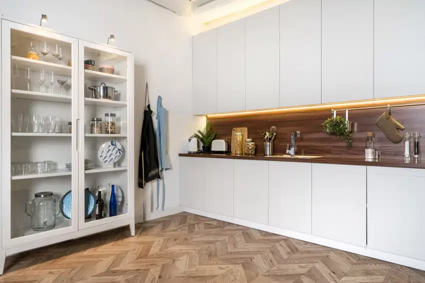 Kitchen with base cabinet, wood herringbone floor and wooden backsplash