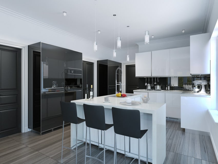 Modern kitchen with freestanding appliance cabinet, bar counter, chairs, pendant lights, backsplash, and wood flooring